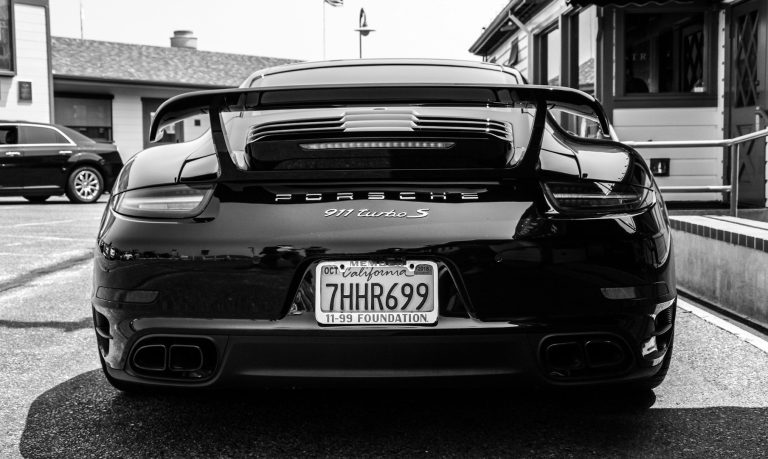 Black sports car with a prominent rear spoiler and license plate visible.