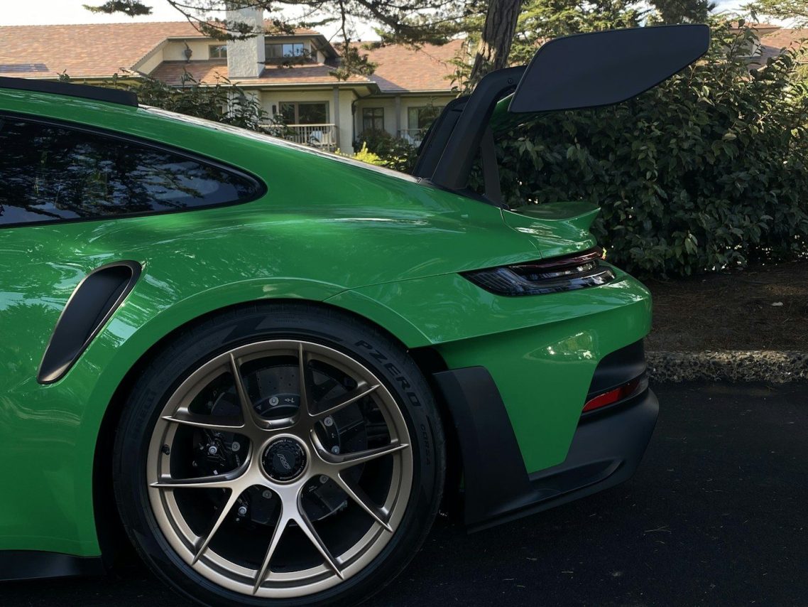 Green sports car with a prominent rear spoiler and gold alloy wheels.